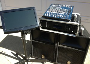 Portable sound mixer setup with monitor and speakers on a stand.