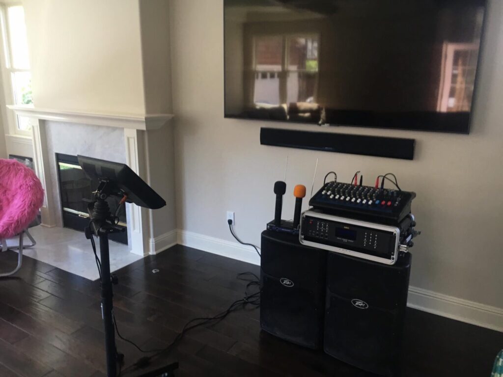 A living room with audio equipment set up in front of a fireplace and a flat-screen tv mounted on the wall.